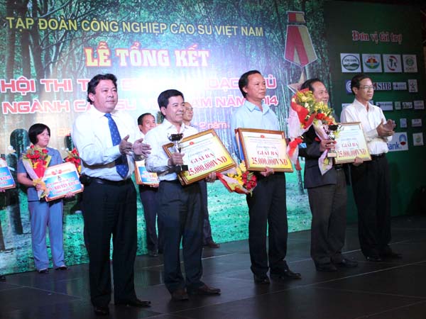 Chủ tịch CĐ CSVN phan Mạnh Hùng (bên trái) và Phó TGĐ VRG Nguyễn Văn Tân (bên phải) trao giải ba tập thể Hội thi Thợ giỏi thu hoạch mủ Ngành Cao su năm 2014. Ảnh: Phan Thắng