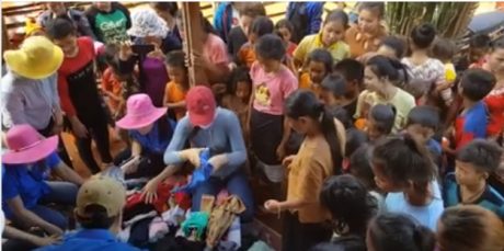 Chi đoàn Nông trường Bachiang IV phát quần áo cũ cho các em ở bản Đôn, huyện Bachiang, Champasak. 