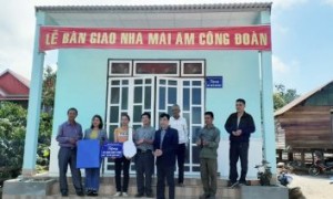 Các đại biểu và gia đình chị H'Tách trước căn nhà bán giao