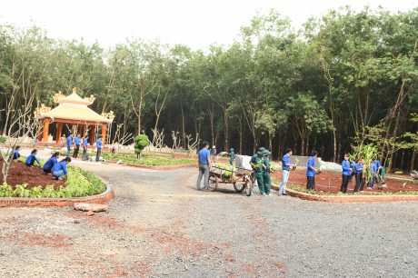 Đoàn viên Thanh niên và công nhân Công ty CPCS Đồng Phú trồng hoa trong khuôn viên di tích đang được tôn tạo. ẢNH: Vũ Phong.